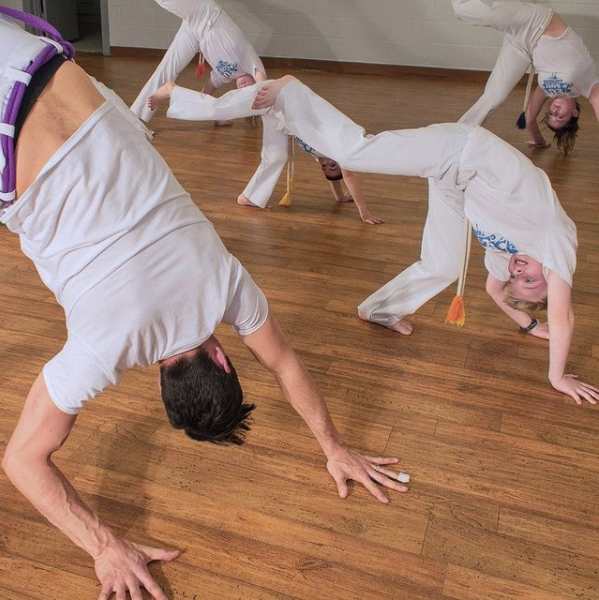 instructor teaching capoeira to kids